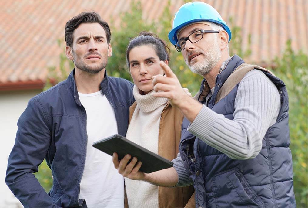 A man and a woman stood with a builder